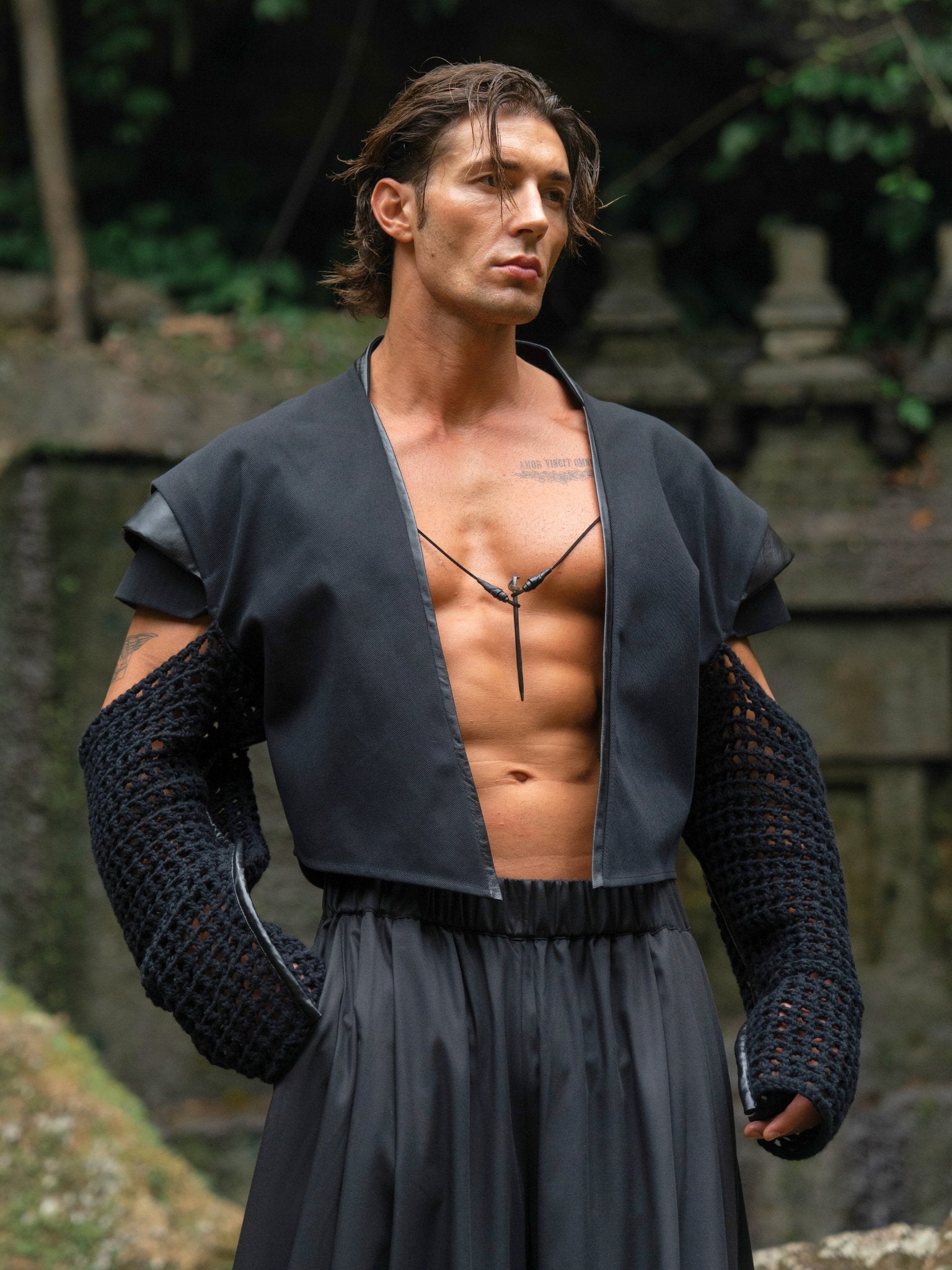 Black cropped denim jacket with knitted sleeves, leather inserts on the back and shoulders, and a bold, unique design that highlights individuality.