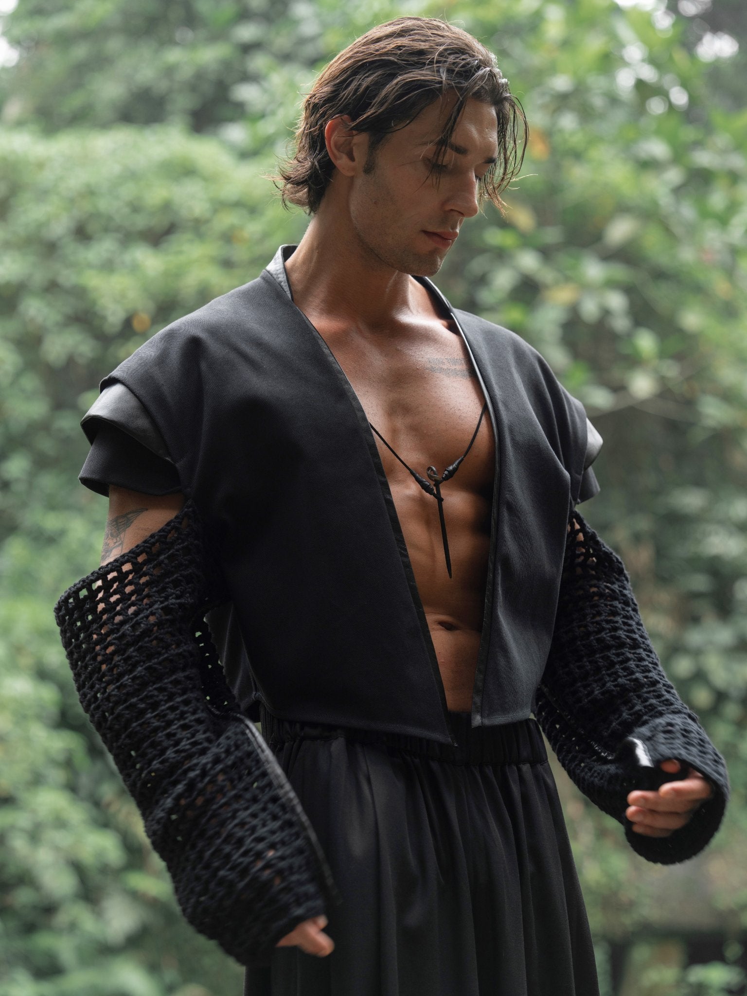 Black cropped denim jacket with knitted sleeves, leather inserts on the back and shoulders, and a bold, unique design that highlights individuality.