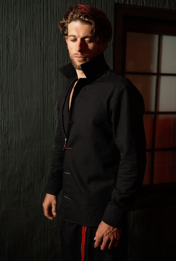 Designer black shirt-jacket menswear piece, lightweight structured fabric, relaxed silhouette, urban style look.