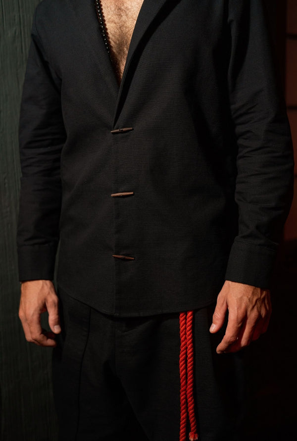 Black men’s shirt jacket by OVERZ, minimalist designer menswear layer, tailored fit, styled with joggers in Bali.