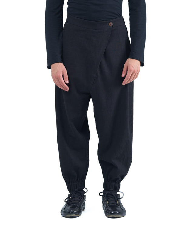 Black asymmetric jogger pants with elastic cuffs and textured fabric by OVERZ