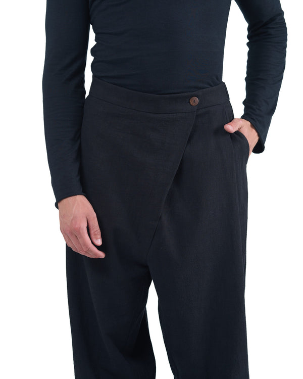 Black asymmetric jogger pants with elastic cuffs and textured fabric by OVERZ