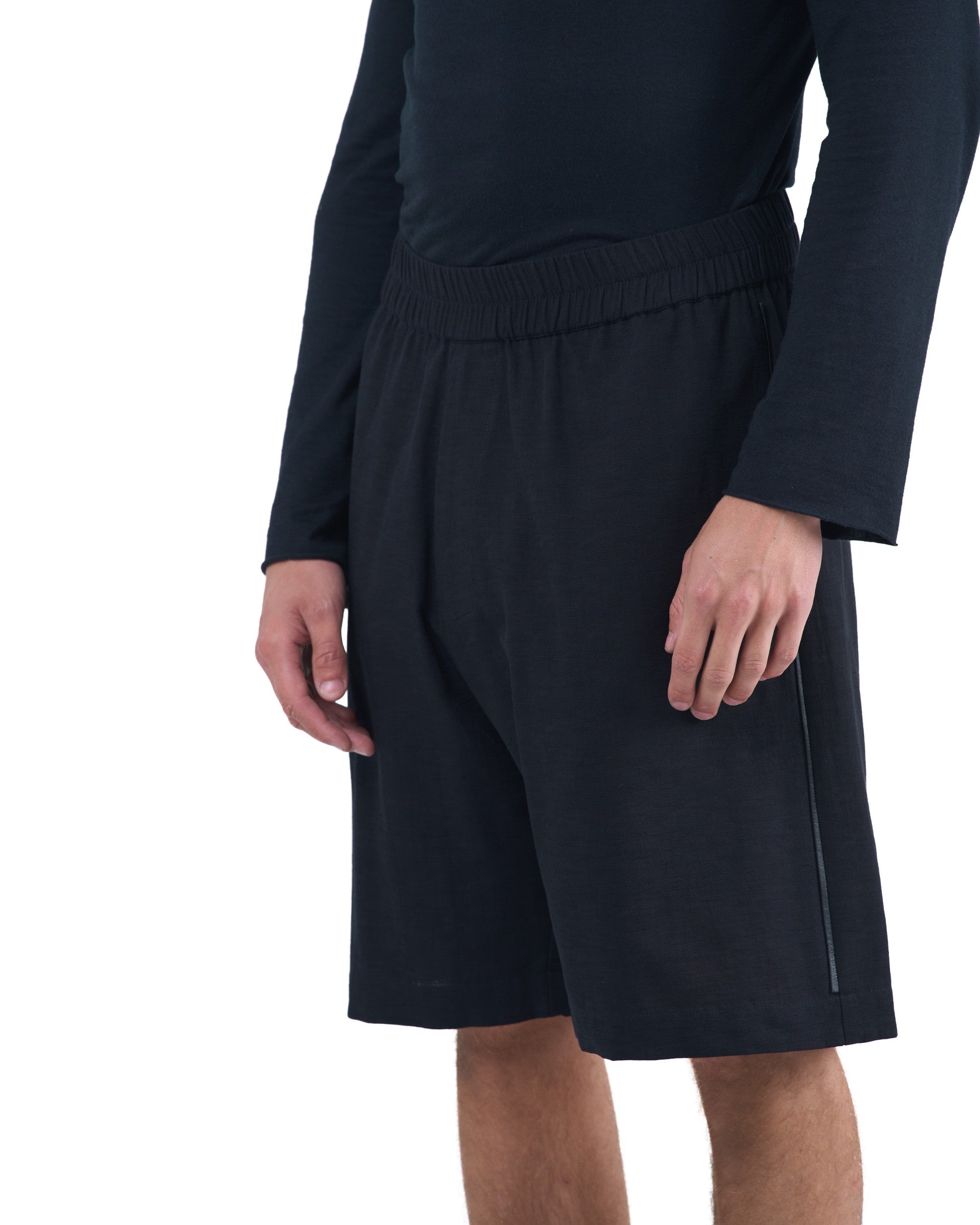 Black textured cotton shorts with leather side inserts and knee-length cut by OVERZ