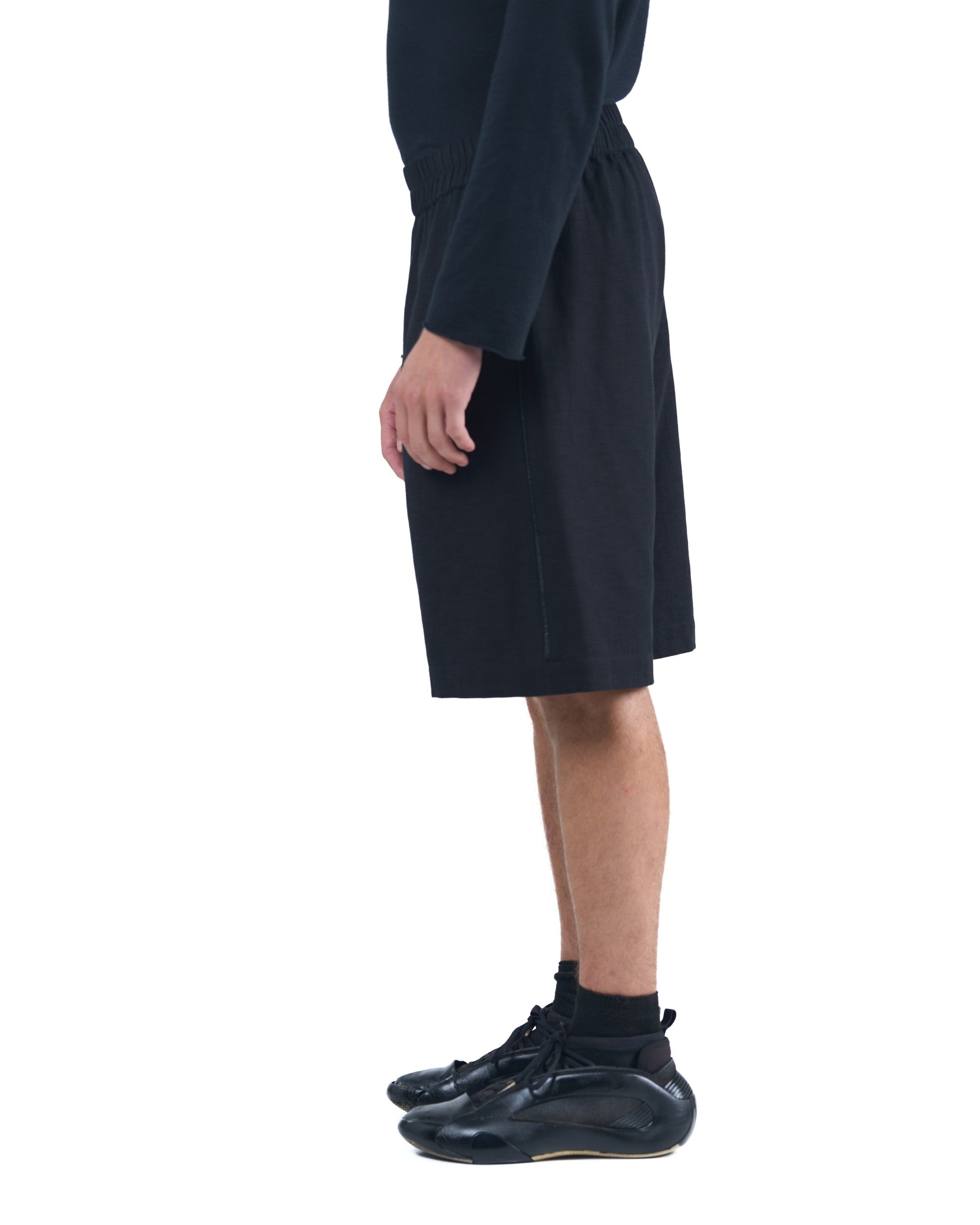 Black textured cotton shorts with leather side inserts and knee-length cut by OVERZ