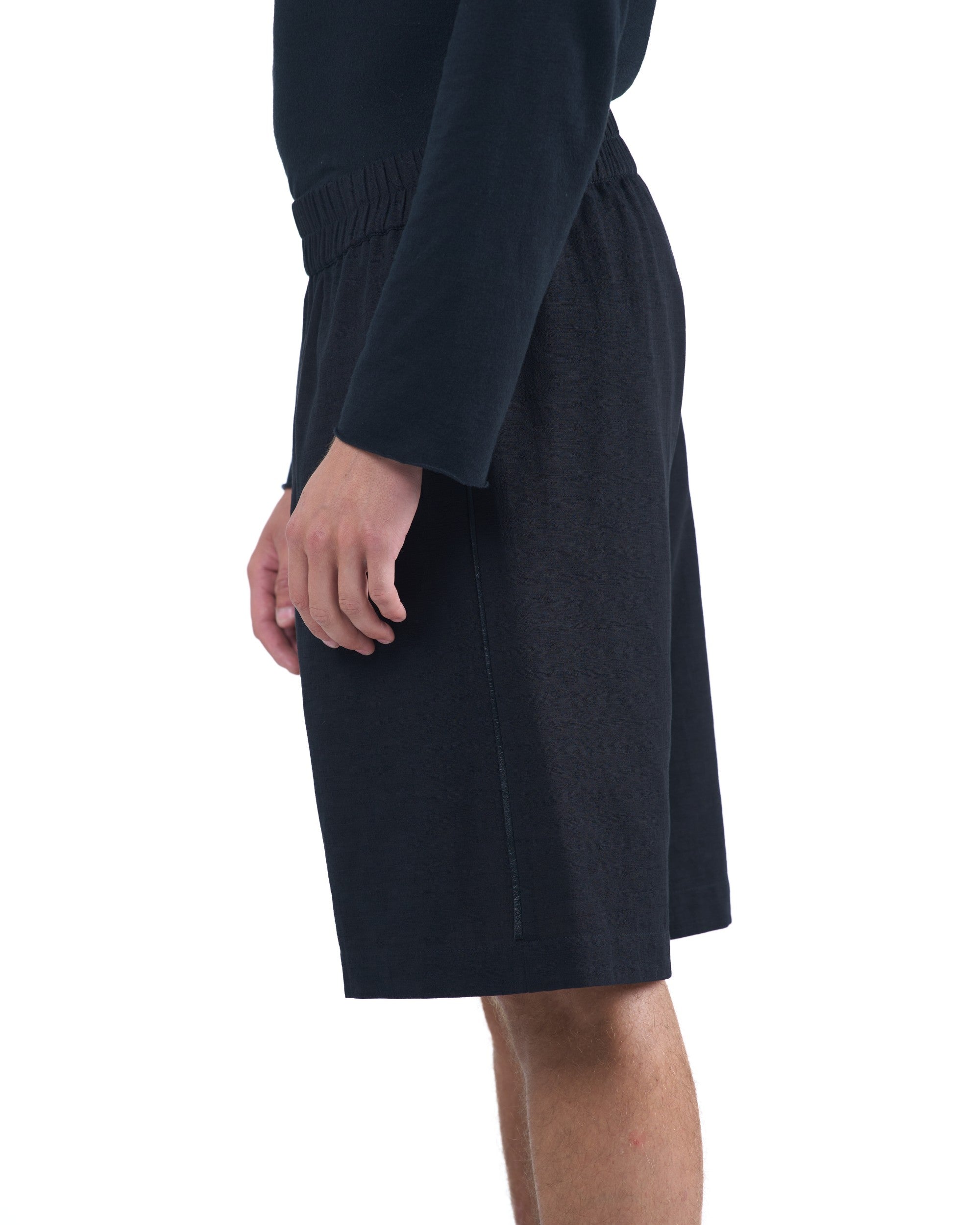Black textured cotton shorts with leather side inserts and knee-length cut by OVERZ