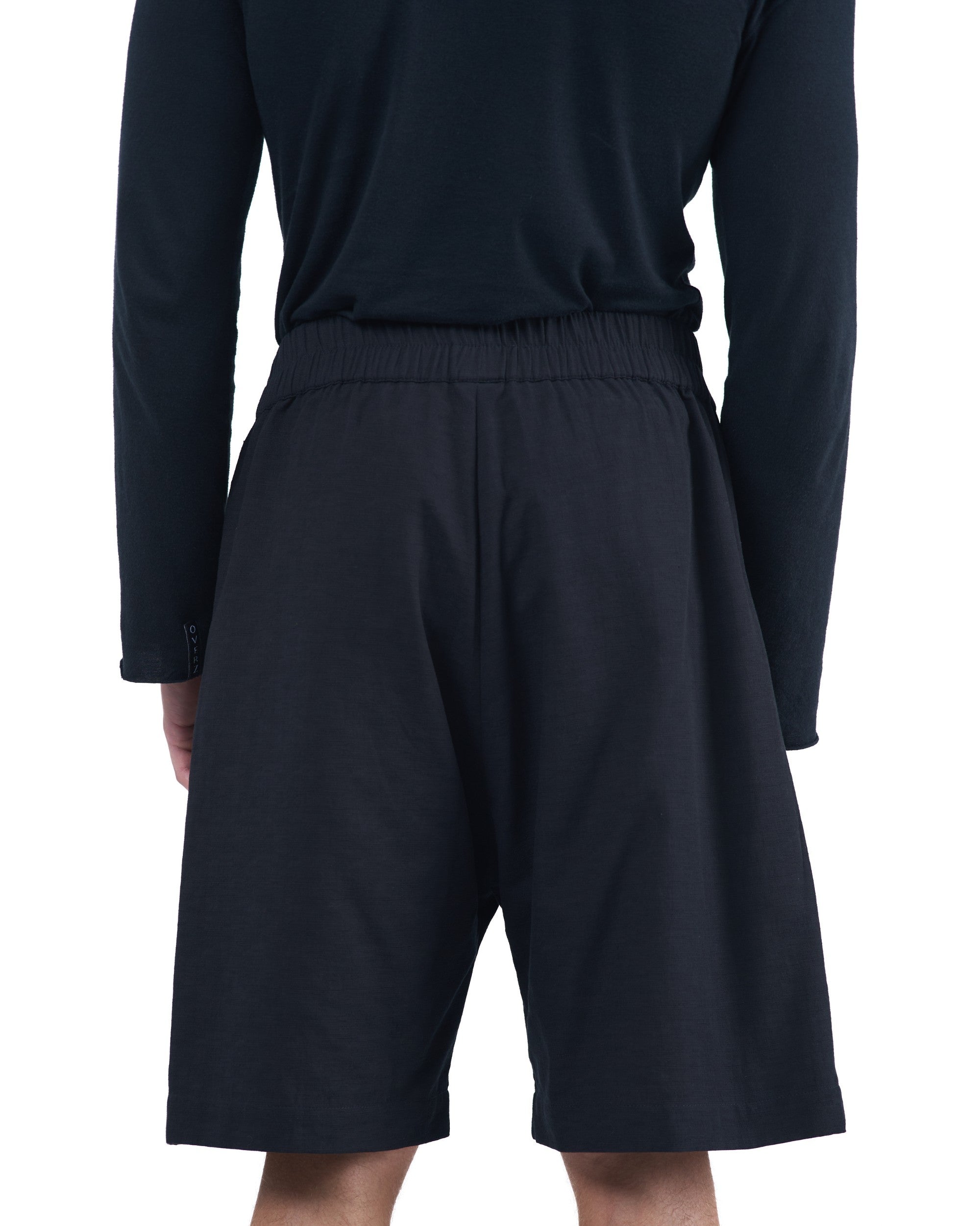 Black textured cotton shorts with leather side inserts and knee-length cut by OVERZ