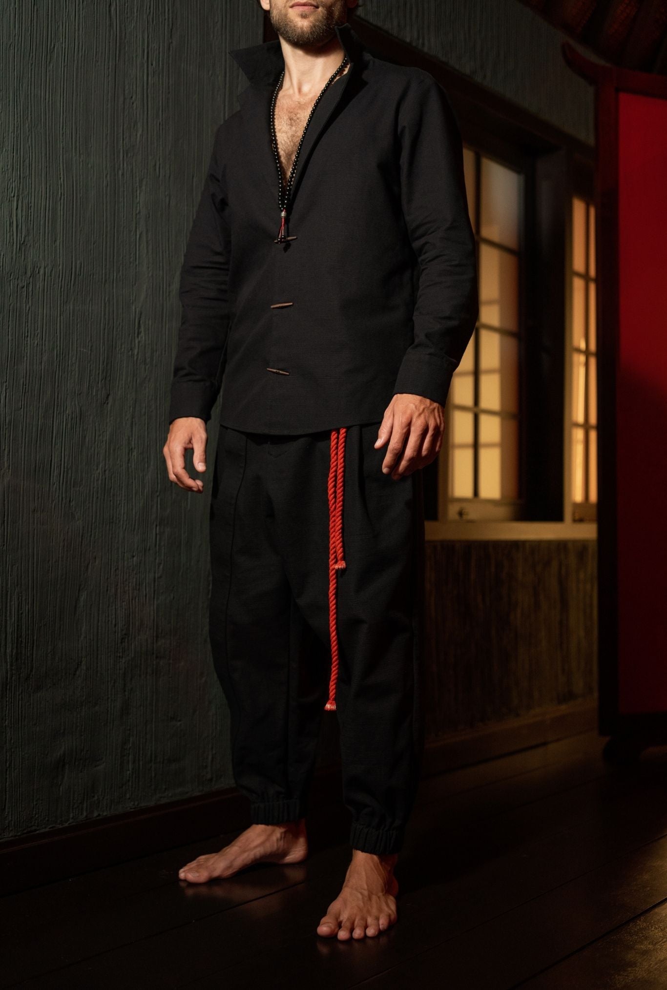 Men wearing black jogger pants with relaxed silhouette and freedom of movement, modern menswear by OVERZ